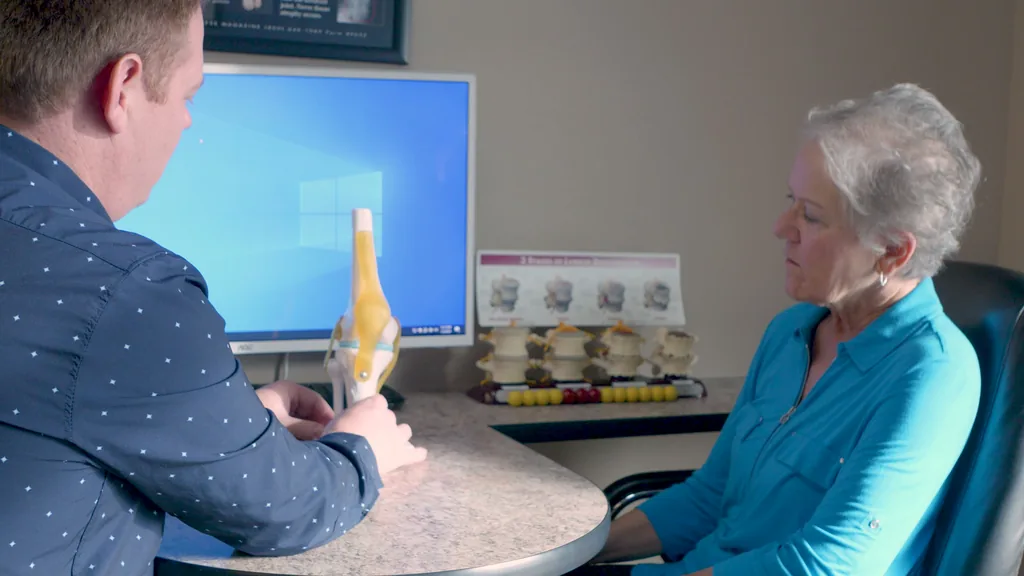 Dr. Kent Rookstool explains a knee model to a patient