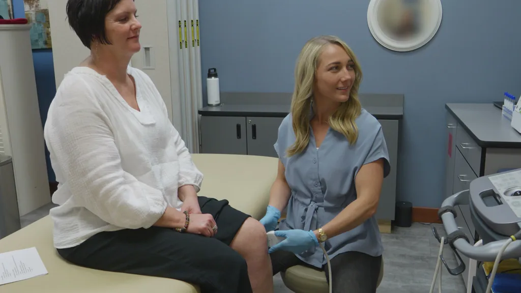 Summerlyn Ellis, FNP-C talks with a patient in a treatment room at Advanced Pain Solutions